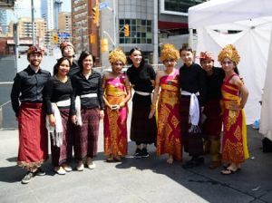 10 individuals in Indonesian cultural clothing posing on the street