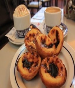 plate of Portuguese custard tarts with 2 cups of coffee