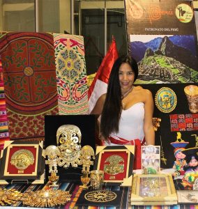 a lady behind a table of Peruvian artifacts